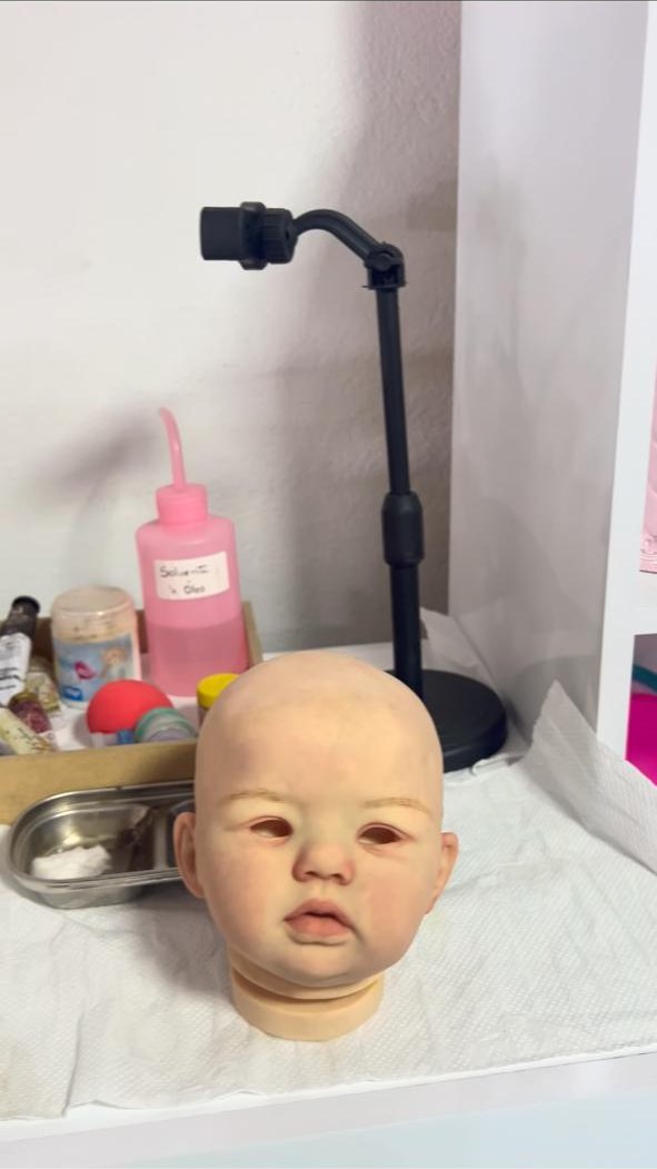 Cabeça de kit reborn em vinil durante o processo de pintura no ateliê